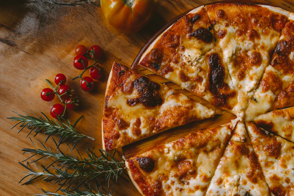 Große Pizza mit Tomaten und Käse auf einem Holzbrett