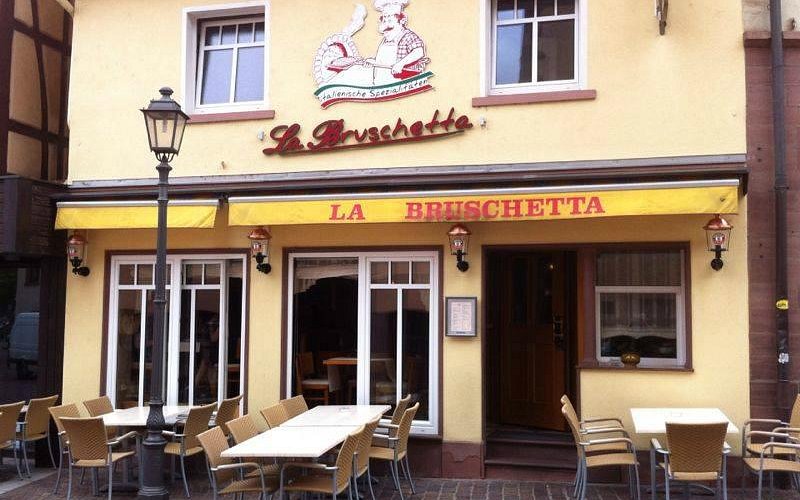 Gelbe Fassade des Restaurants La Bruschetta in der Turmstraße mit Markise und Außenplätzen